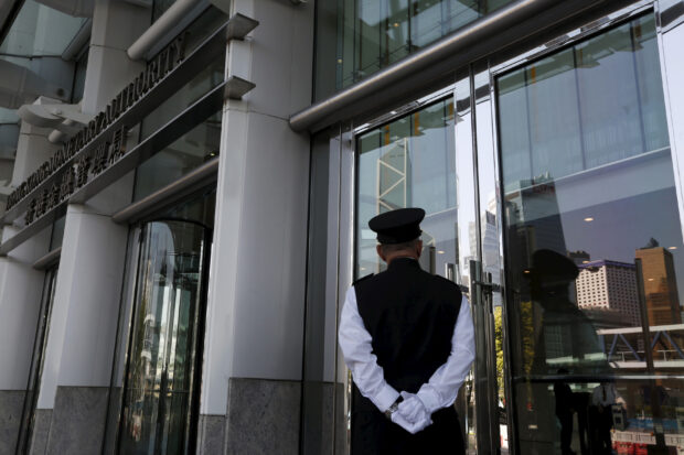 A guard stands in front of the entrance to the Hong Kong Monetary Authority