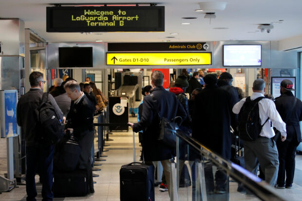 Travelers wait in lines at LaGuardia Airport in New York when hundreds of flights were grounded