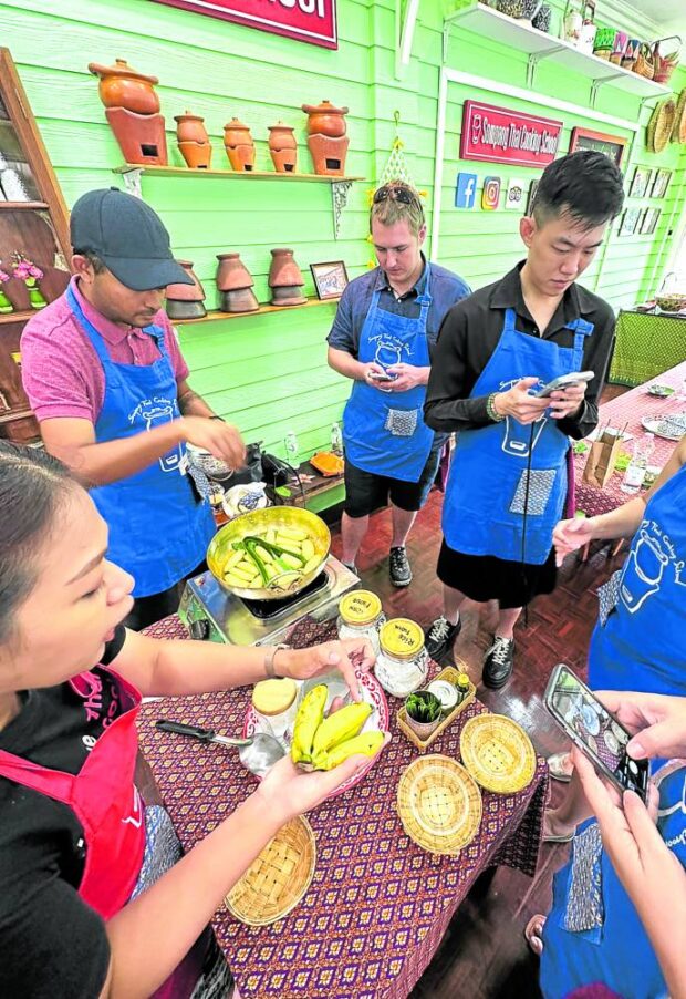 WOK TO TABLE Chef Ant (leftmost) teaches foreigners howto cook authentic Thai dessert at Sompong Thai Cooking School in Bangkok. —PHOTOS BY DORIS DUMLAO-ABADILLA
