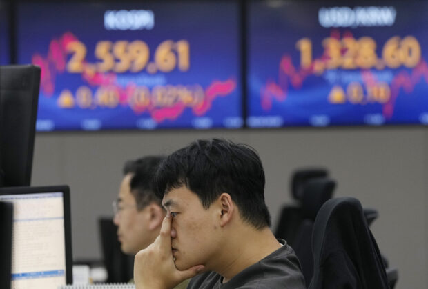 A currency trader watches monitors at the foreign exchange dealing room in Seoul