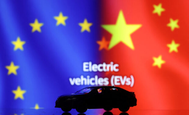 Illustration shows miniature EVs with EU and China flags in the background 