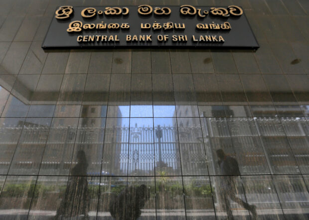 People walking past the main entrance of Sri Lanka's central bank in Colombo.