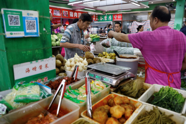 A pickle vendor attending to a customer at a market in Beijing