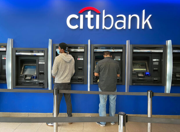 Customers use ATMs at a Citibank branch in Queens borough, New York City