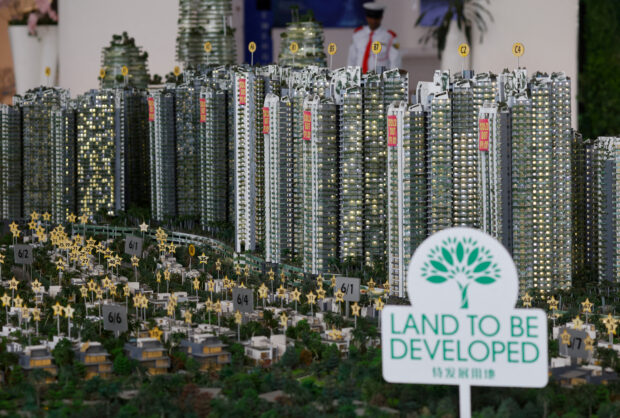 A model shows sold-out signs on residential blocks at a showroom of Country Garden in Bahru