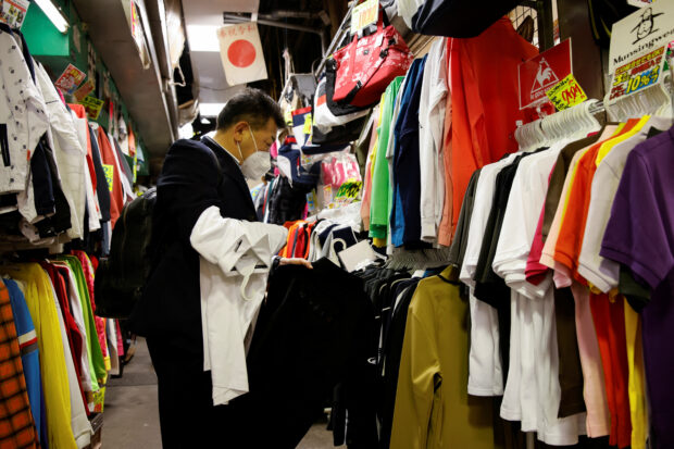 A man shops for clothes at a market in Tokyo