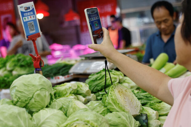 Consumer scans QR code to pay for vegetables at a market in Beijing