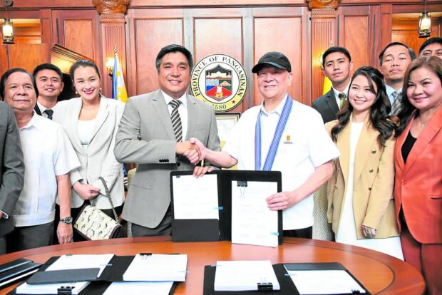 VITAL LINK Ramon Ang (right), president and CEO of San Miguel Corp. (SMC), signs the jointventure agreement and toll concession agreement with Pangasinan Gov. Ramon Guico III for the Pangasinan Link Expressway, a 76.8-kilometer expressway linking the western corridor of the province to its eastern side. —PHOTO FROM SMC