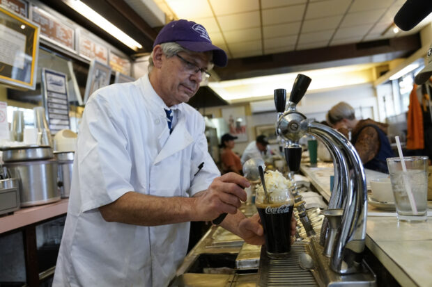 John Philis, owner of the Lexington Candy Shop, prepares a Coke float at the luncheonette in New York