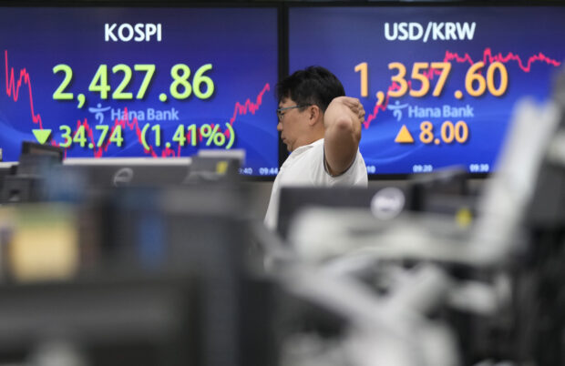 A currency trader watches monitors showing the Korea Stock Price Index