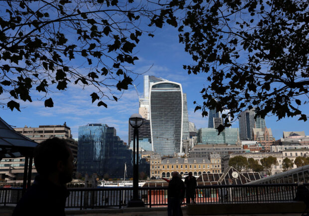 People walk alongside the City of London financial district 