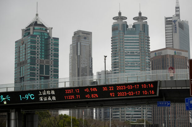 An electronic board showing Shanghai and Shenzhen stock indices in Shanghai