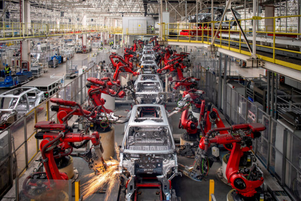 Robotic arms assemble cars in the production line for Leapmotor's EV factory in Chian