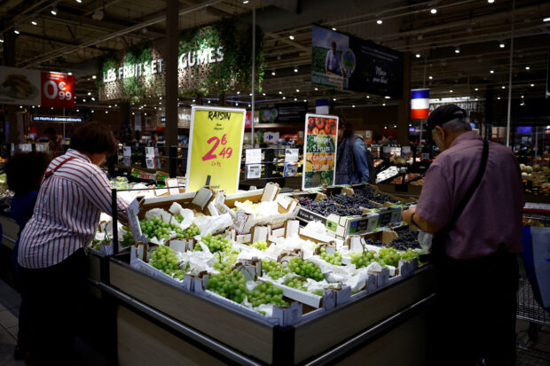 Customers shop at the fruits and vegetable section i a Carrefour supermarket in Montesson near Paris