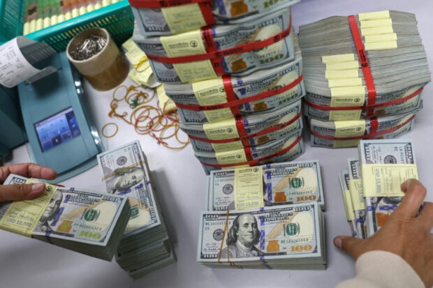 Bank employee gathers US dollar notes