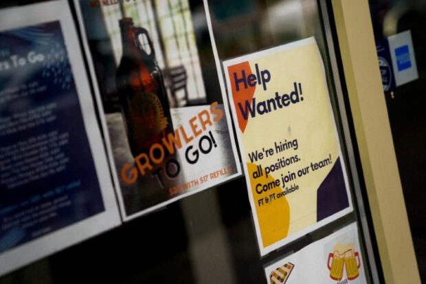 Employee hiring sign in a window of a business in Arlington, Virginia