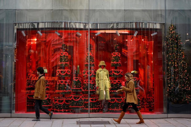 People walk past the festive window decorations for the Christmas season in Paris