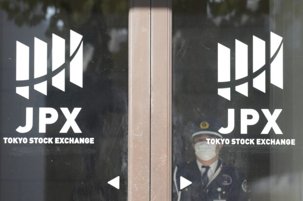 A security guard stand by the door of the Tokyo Stock Exchange
