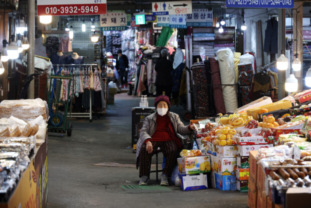 A shopkeeper naps as she waits for customers in Seoul