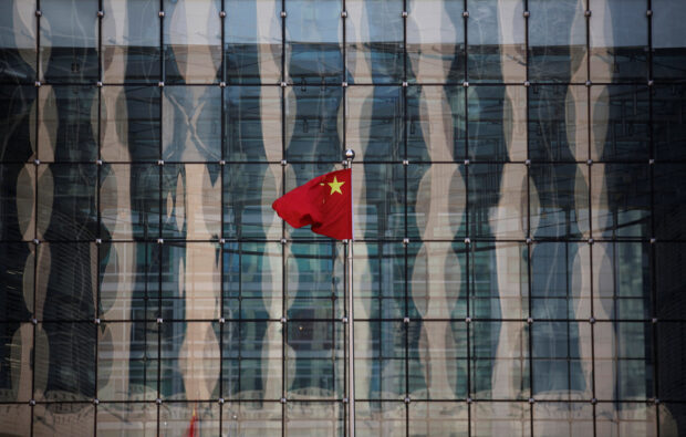 China's national flag flutters at a commercial bank's building in a financial district in Beijing