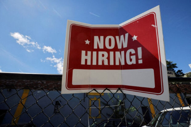 'Now hiring' sign outside a shop in Somerville, Massachusetts