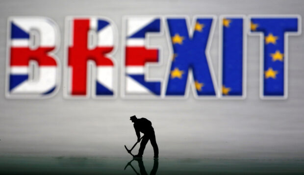 A small toy figure seen in front of a Brexit logo