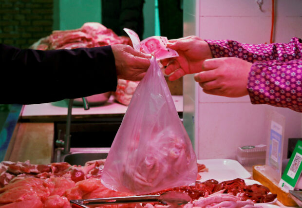 Man pays for meat at a market in Beijing