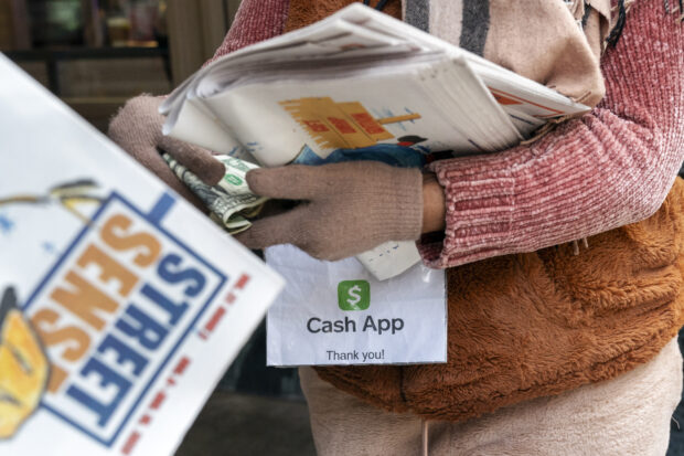 A vendor sells a local paper