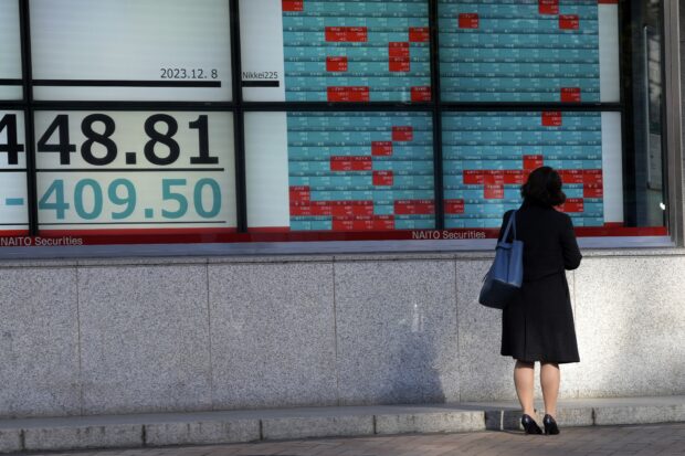 A person looks at an electronic stock board in Tokyo