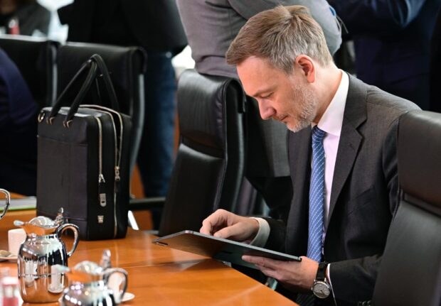 German Finance Minister Christian Lindner looks at a tablet device as he attends the weekly cabinet meeting at the Chancellery in Berlin, Germany 