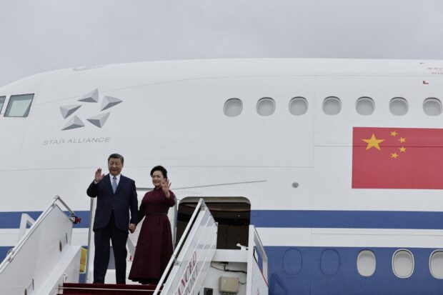 China's President Xi Jinping and his wife Peng Liyuan waves prior to disembarking from their aeroplane upon their arrival for an official two-day state visit, at Orly airport, south of Paris on May 5, 2024. 