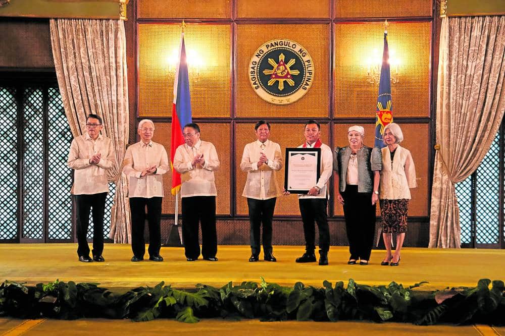 BADGE OF HONOR Kawayan Collective Agricultural Cooperative chair Marbert Tinguha (fifth from left) receives the Presidential Award for Outstanding MSME (small business category) from President Marcos. Also in the photo are (from left): MSME Development Council vice chair and Go Negosyo founder Joey Concepcion, Trade Secretary Alfredo Pascual and Executive Secretary Lucas Bersamin. 