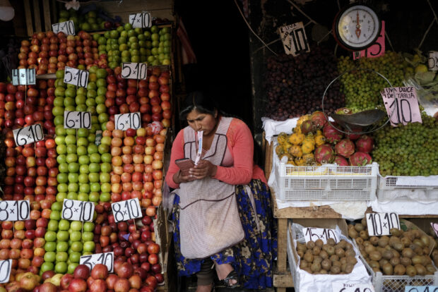 A vendor waits for customers at her produce stand, a day after Army troops stormed the government palace in what President Luis Arce called a coup attempt, in La Paz, Bolivia, Thursday, June 27, 2024. 