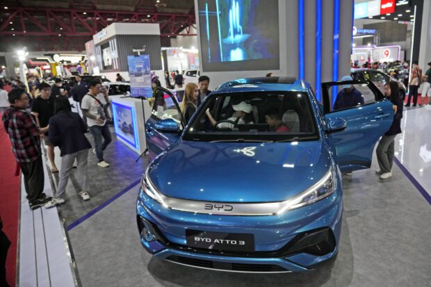 People inspect electric vehicles made by Chinese automaker BYD during an auto fair in Jakarta, Indonesia, Wednesday, June 19, 2024. 