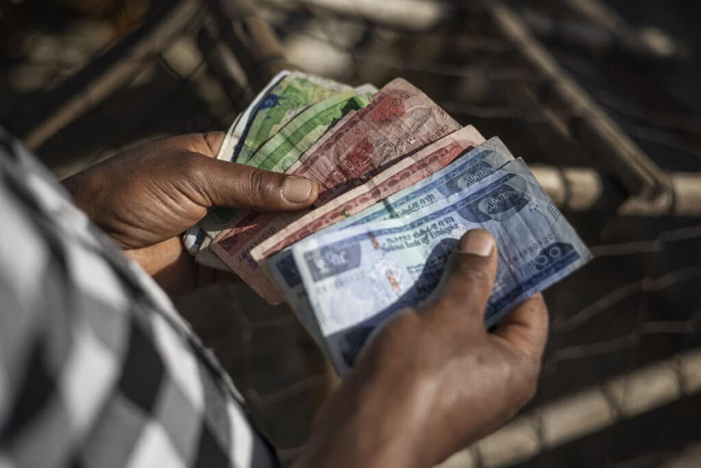 A shop owner counts Ethiopian Birr in his stall at the Shola Market in Addis Ababa on December 4, 2023. 