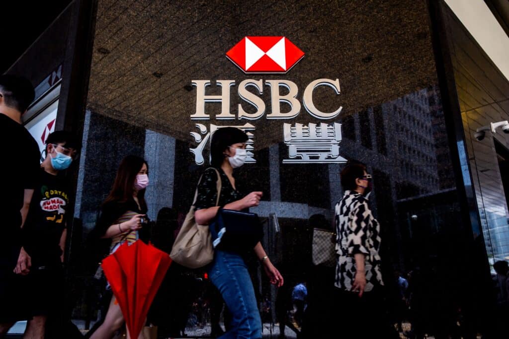 Pedestrians walk past the logo for HSBC outside a local branch bank in Hong Kong on August 2, 2021. 