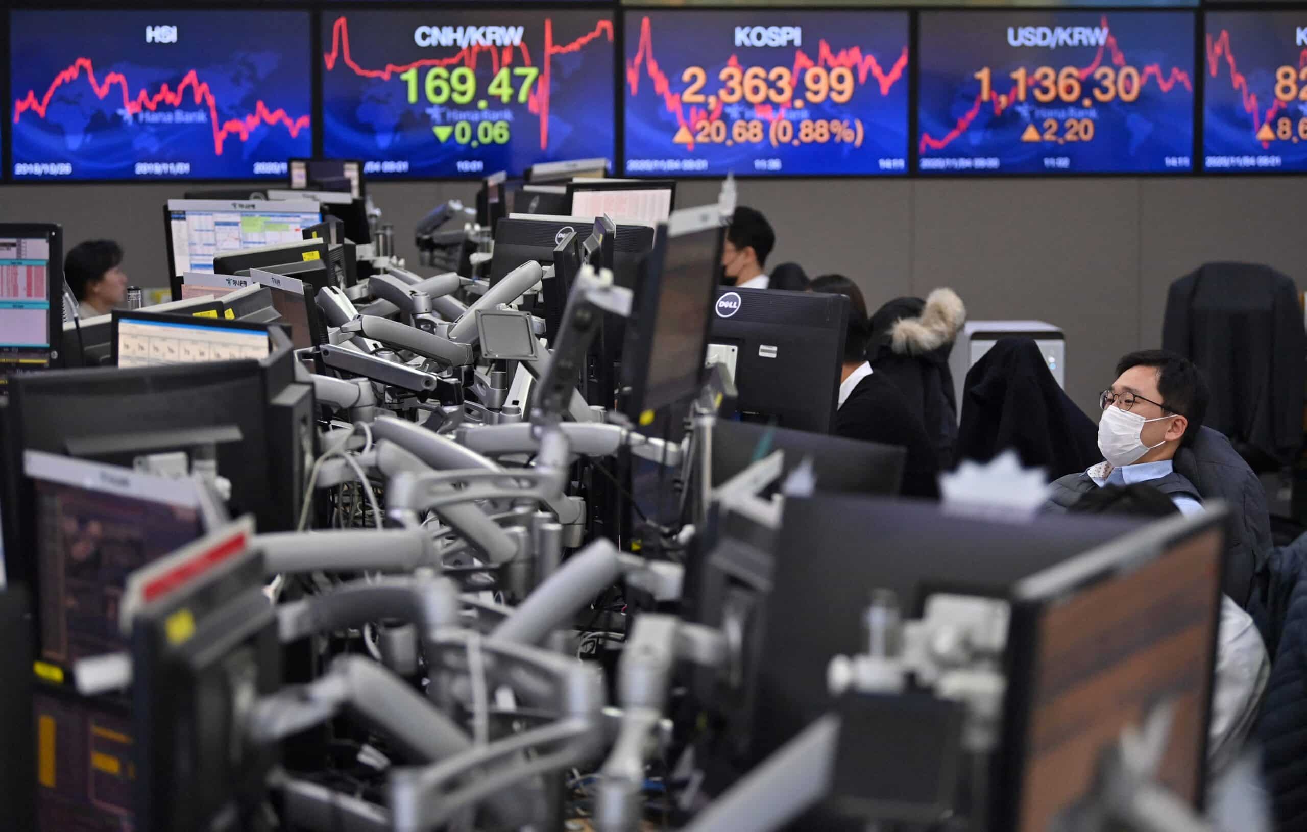 Currency dealers monitor exchange rates in a trading room at KEB Hana Bank in Seoul on November 4, 2020, as Asian markets react to early predictions following the US presidential election. 