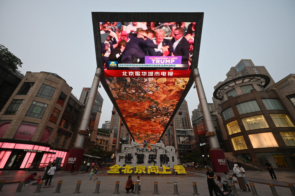 A news program about the assassination attempt on former US president Donald Trump is seen on a giant screen at a shopping mall in Beijing July 14, 2024. 