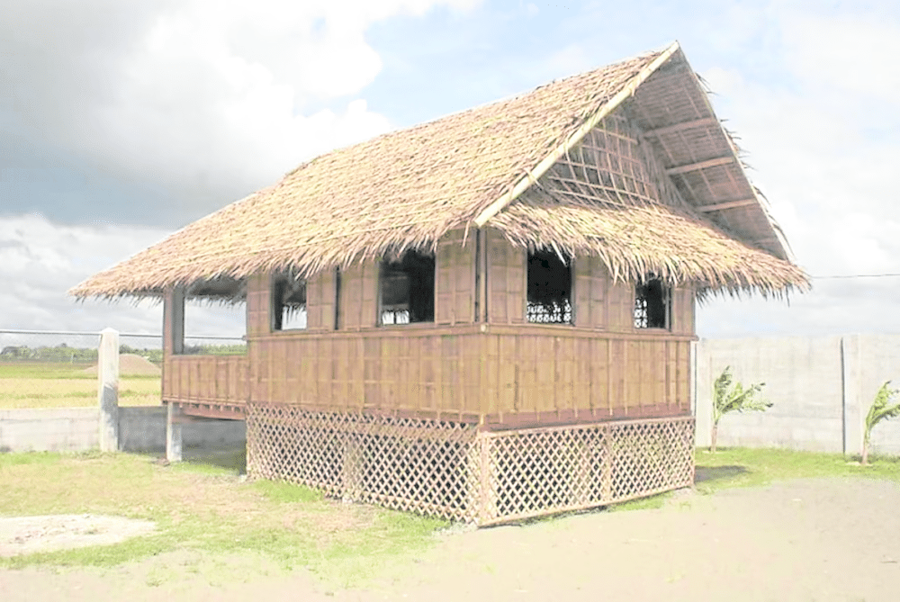 A quintessential Bahay Kubo stands on stilts, showcasing early sustainable architecture in the Philippines. Crafted from bamboo and nipa palm, its elevated design promotes natural airflow and safeguards against frequent flooding in the archipelago.