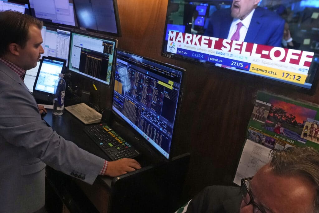 A television screen on the floor of the New York Stock Exchange, Monday, Aug. 5, 2024, headlines trading.