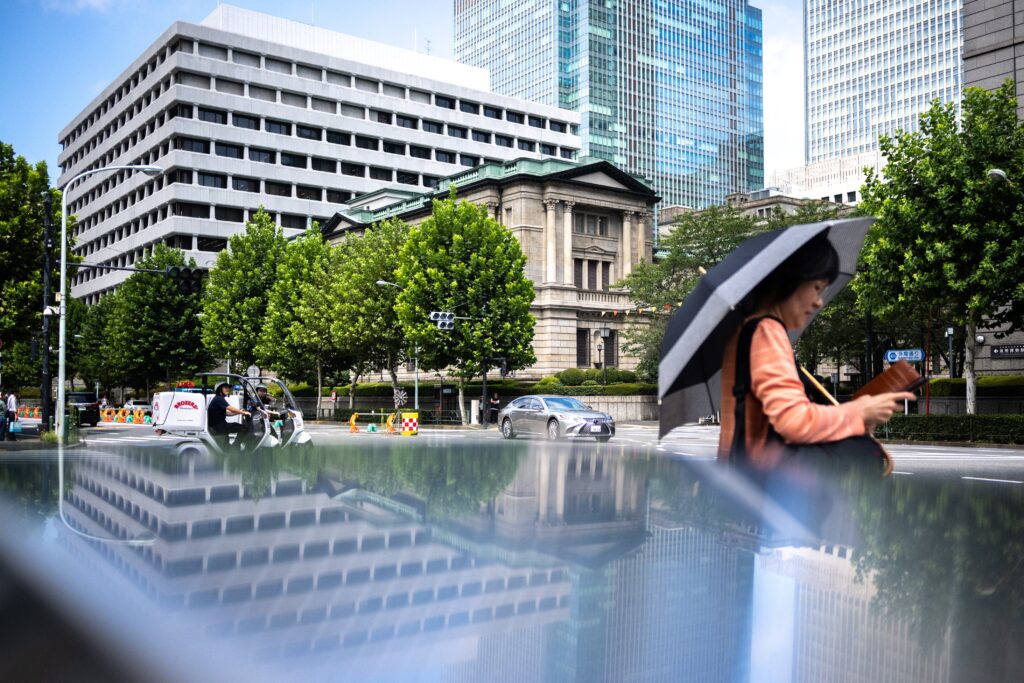 A pedestrian walks in front of the Bank of Japan headquarters in Tokyo on August 23, 2024.