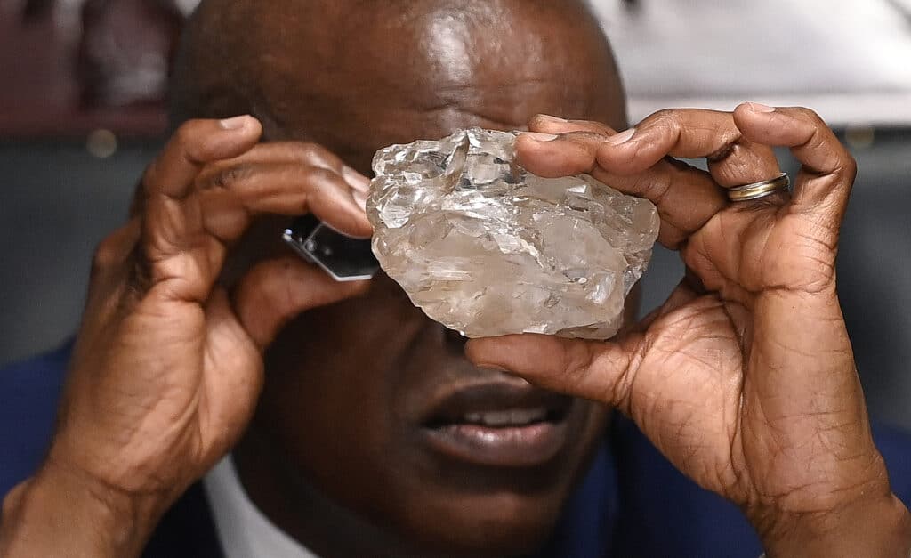 Botswana's President Mokgweetsi Masisi looks at a large diamond discovered in Botswana at his office in Gaborone on August 22, 2024.