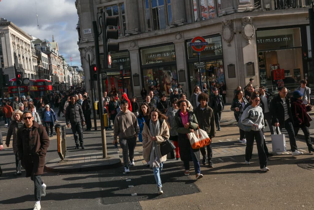 Pedestrians walk in the winter sunshine down Oxford Street in central London on February 16, 2024.