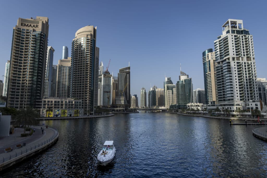 People sit on a boat as it sails along Dubai Marina, United Arab Emirates, Tuesday, Aug. 13, 2024.