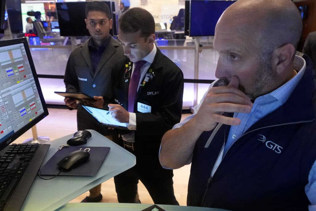 Specialist James Denaro, right, works at his post on the floor of the New York Stock Exchange, Monday, Aug. 5, 2024.