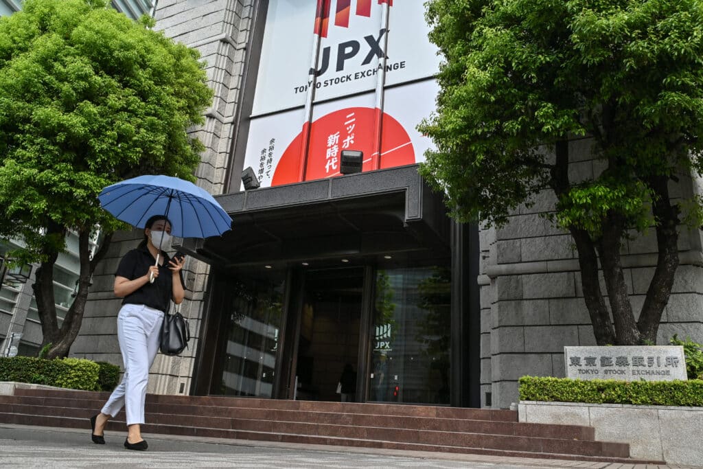 A woman walks past the Tokyo Stock Exchange building along a street in Tokyo on August 14, 2024.