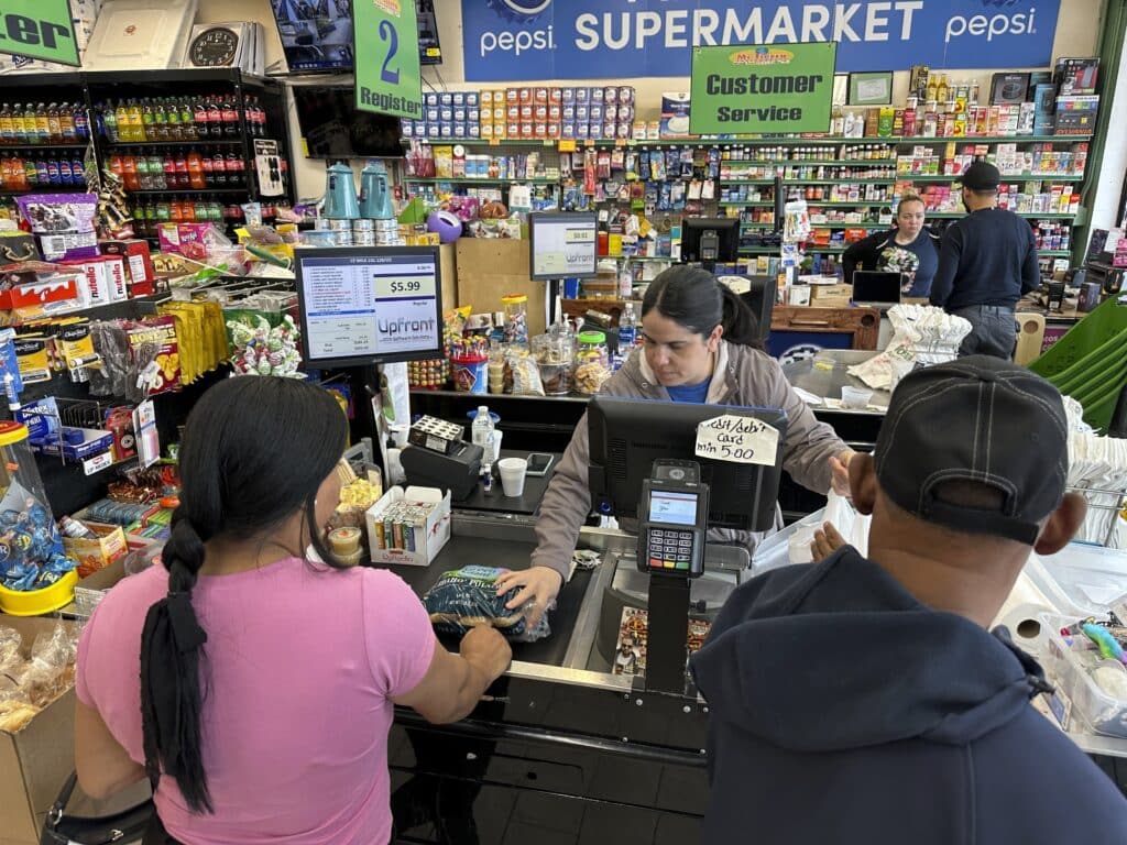 Cashier Rosa Dilone helps customers at Mi Tierra Supermarket in Hazleton, Pa., on May 16, 2024. 