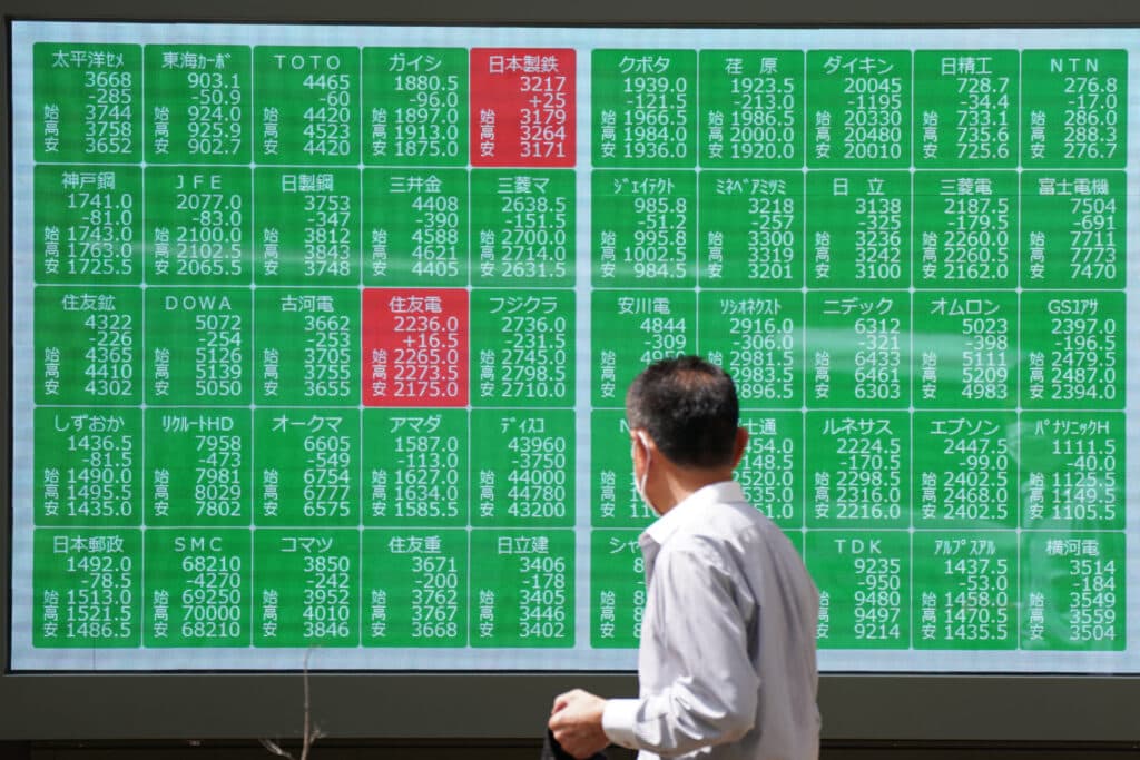 A man looks at an electronic quotation board displaying stock prices of Nikkei 225 on the Tokyo Stock Exchange in Tokyo on August 2, 2024. 