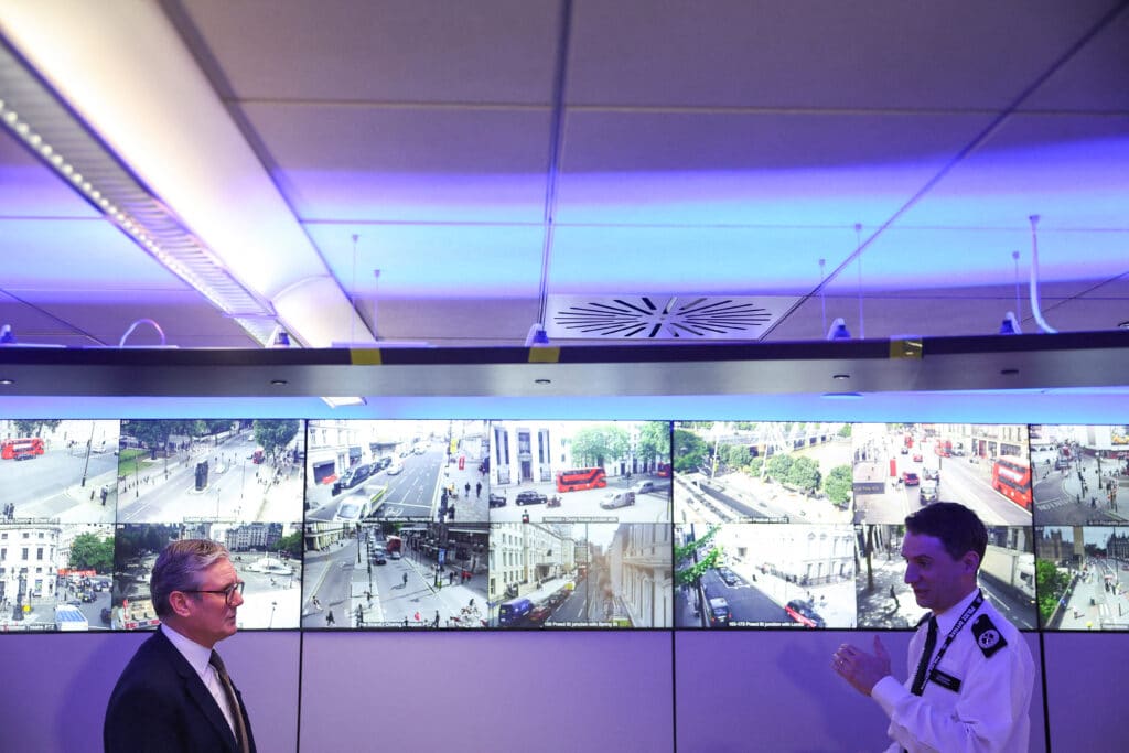 Britain's Prime Minister Keir Starmer (L) speaks with Commander Ben Russell besides CCTV screens in the Engineering Suite in the Metropolitan Police Command and Control Special Operations Room at Lambeth Police Headquarters in London on August 9, 2024.