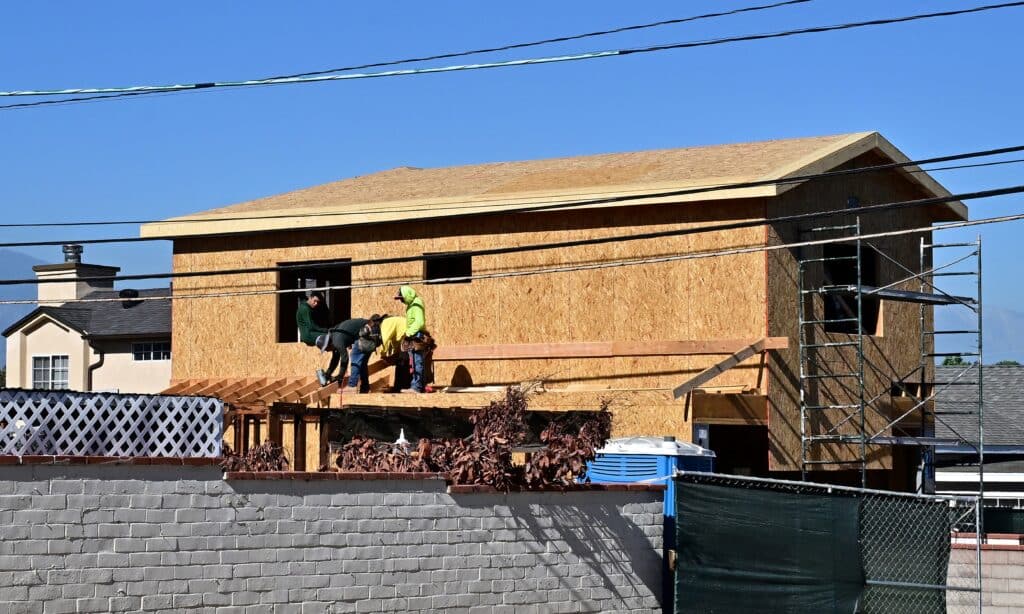 Laborers work on the exterior of a new house being built in Alhambra, California, on August 21, 2024.